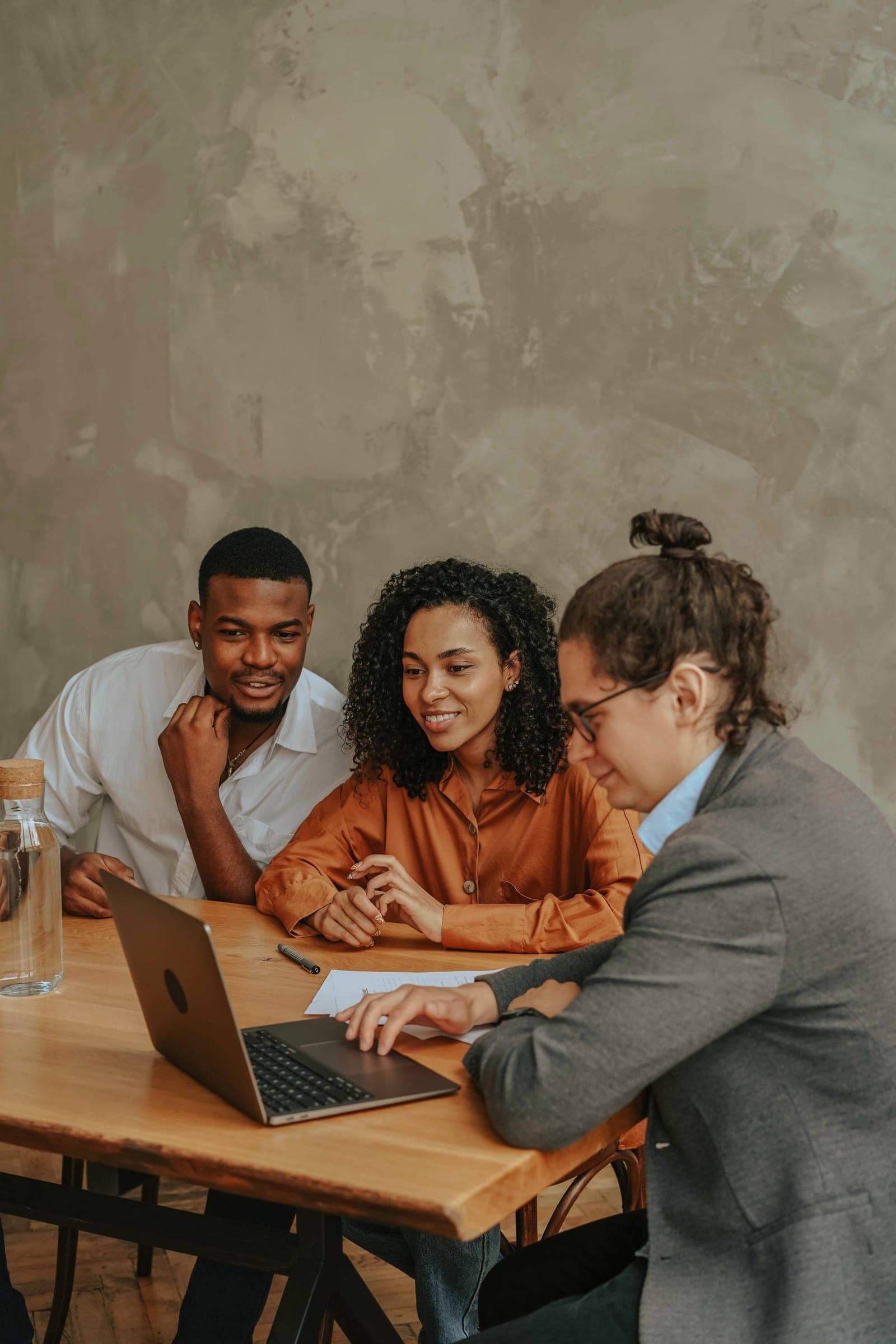 A staffing team reviewing placements together at a laptop