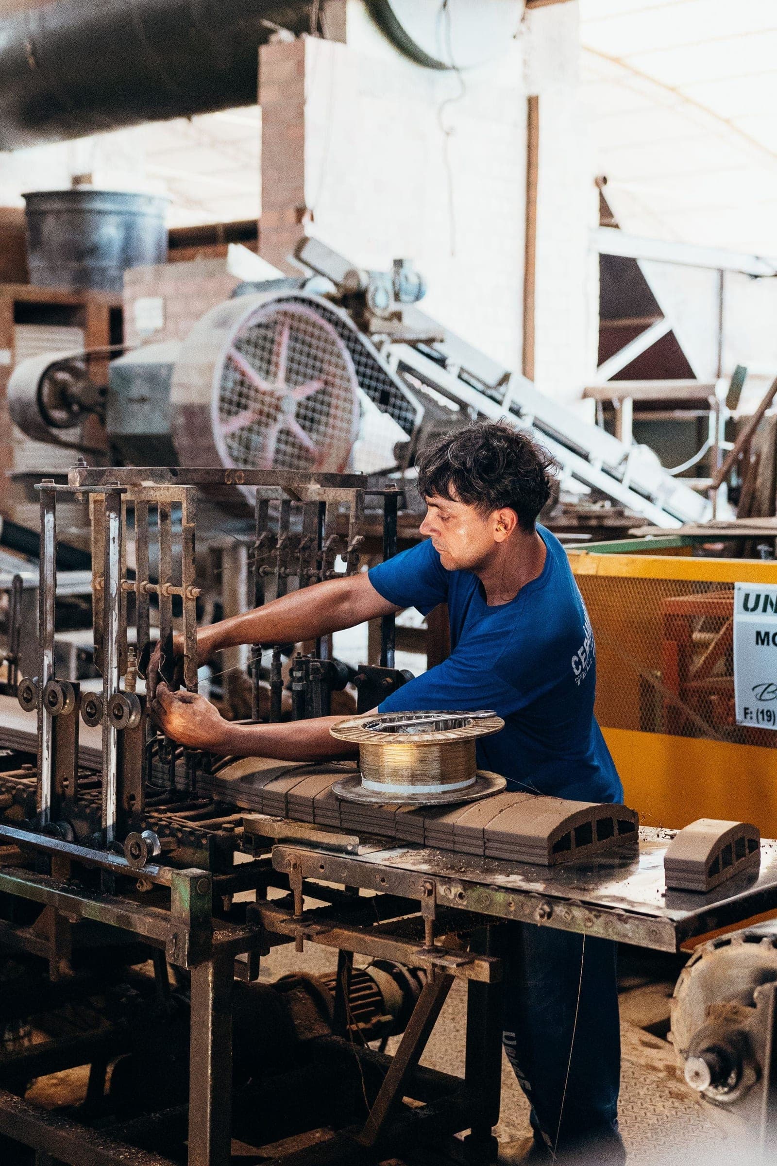 A machinist working on equipment on a factory floor